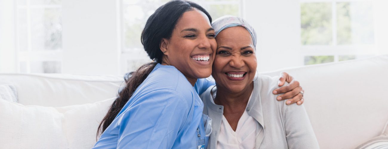 Elderly woman enjoys her nurse An elderly woman enjoying an embrace from her at home healthcare nurse.