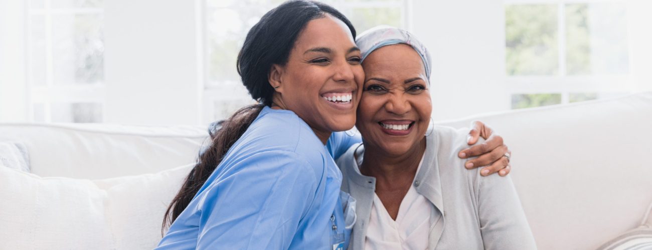 An elderly woman enjoying an embrace from her at home healthcare nurse.